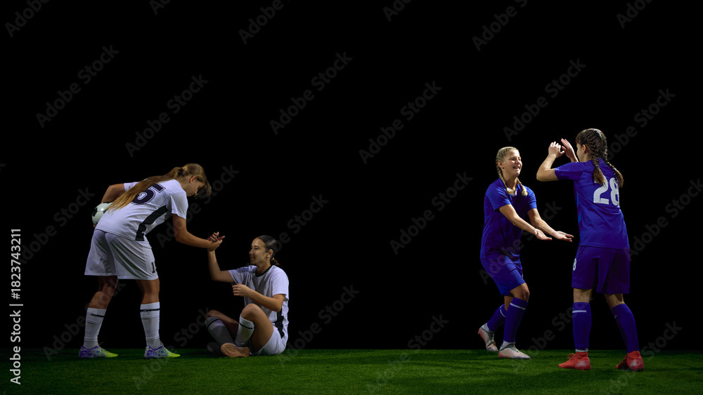 Fototapeta premium Female soccer players helping teammate after fall during match. Concept of fair play lessons, sports ethics materials, social values education, teamwork campaigns.