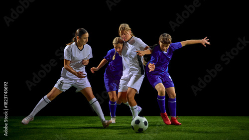 Obraz na plátně Teenage girls soccer players fighting for ball in multi-player action cluster