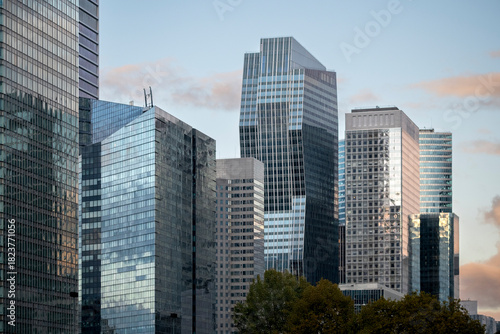 Architecture and skyscraper façades in Paris where reflection surfaces highlight finance and business ideas throughout the urban landscape belonging to the corporate district of La Defense.