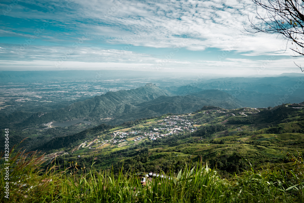 Fototapeta premium Beautiful mountain landscape with sea of mist, winding road, and resorts at Phu Thap Boek, Thailand.