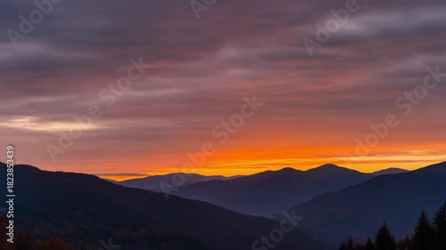Wallpaper Mural Vibrant orange and purple sunset sky glowing over silhouetted mountain ranges in a peaceful valley Torontodigital.ca