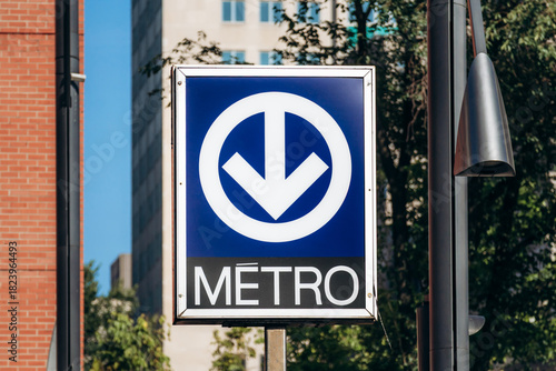 Montreal, Canada – August 12, 2025: Metro sign with a blue background and downward arrow in downtown Montreal.