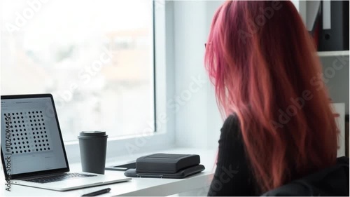 Woman with pink hair working from home in bright office space