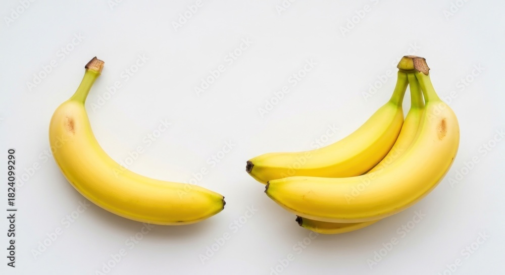 Fototapeta premium Yellow bananas on a plain white background, one separate, one in a bunch