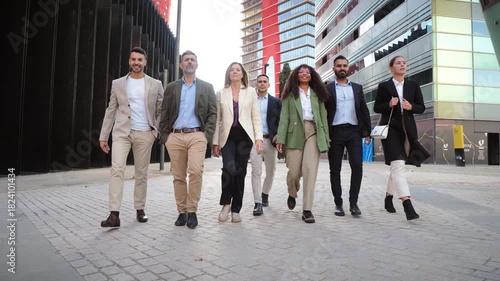 A determined group of businesspeople confidently walking together in stylish professional attire, showcasing teamwork and collaboration in a corporate setting, embodying success and partnership.