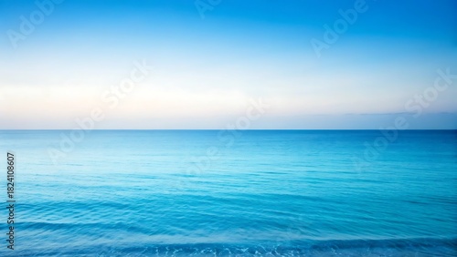 Fototapeta Naklejka Na Ścianę i Meble -  Vast ocean horizon under a gradient blue sky, serene water surface with gentle ripples and soft light.
