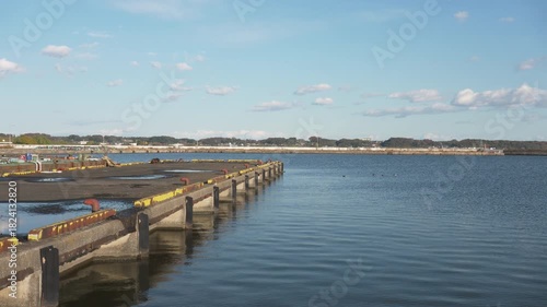 Wallpaper Mural Rippling Lake Surface and an Abandoned Tire Against a Concrete Embankment Torontodigital.ca