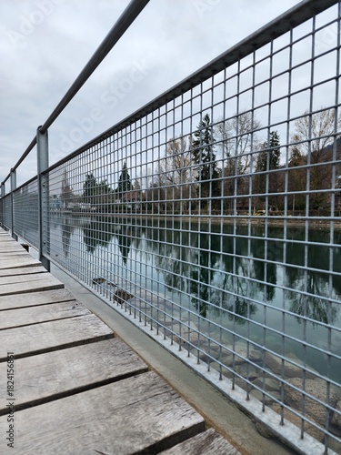 The waterfront promenade is beautifully and neatly fenced with metal mesh, and the walkway is made of neatly arranged wooden planks.