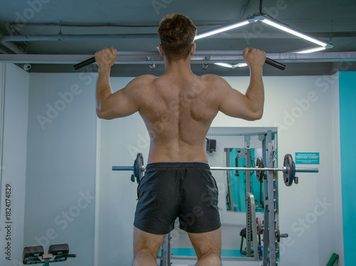 muscular man lifting weights young bodibuilder sports fitness pull up chin ups