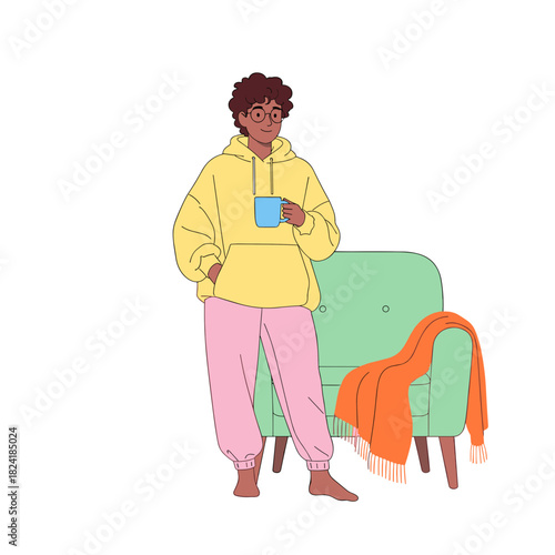 Non-binary person relaxing at home in casual outfit with a mug  