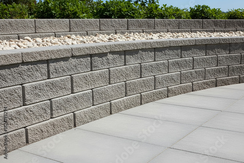 Modern retaining wall with decorative stone and pavers in an outdoor setting