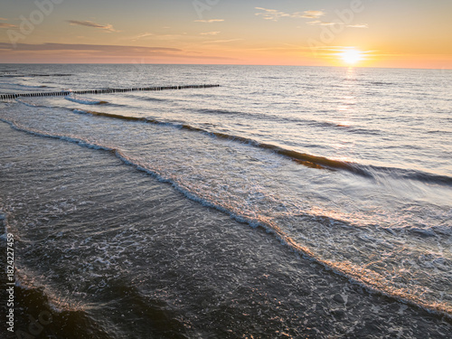 Waves and sun on horizon at Baltic Sea at sunset