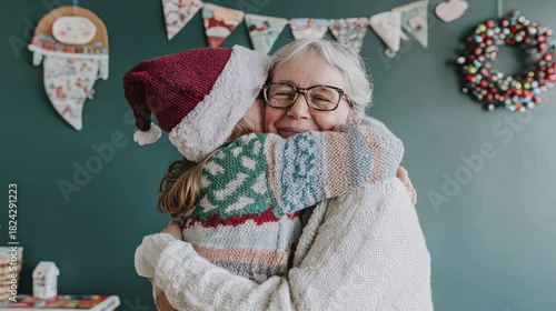 Heartwarming christmas hug between grandmother and granddaughter in festive sweaters