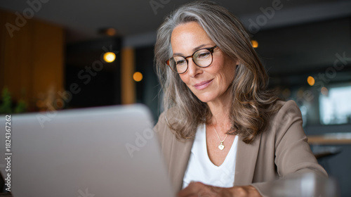 Wallpaper Mural Middle age European business woman CEO using laptop application for work at table workspace in office. Smiling Latin Hispanic mature adult professional businesswoman using pc digital computer. Torontodigital.ca