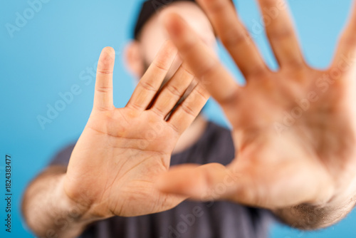 Billede på lærred Close-up shot of a man's hands raised, blocking the view