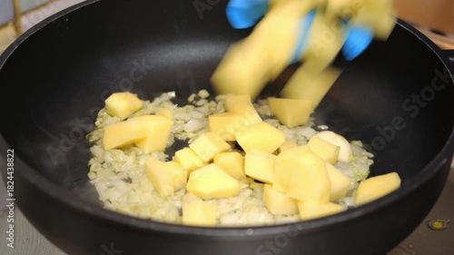 Cuoco mette le patate nella pentola e le mescola 
