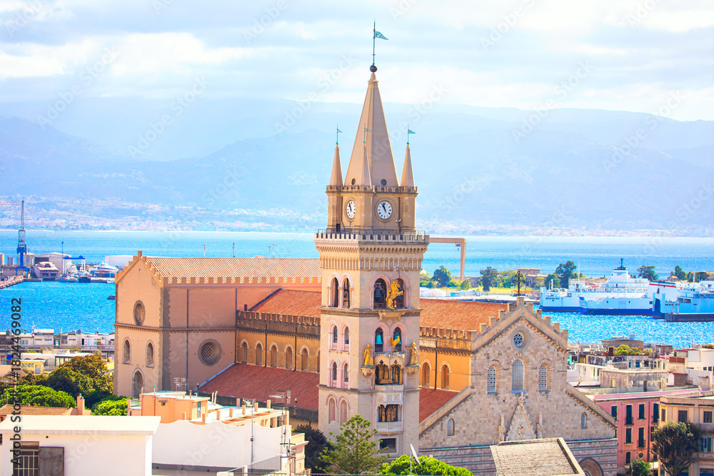Obraz premium Messina Cathedral in Sicily, Italy, with its distinctive bell tower. Building overlooks the Strait of Messina and a bustling port. Duomo di Messina with prominent clock tower