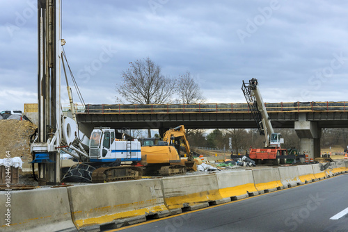 Fotografie Heavy machinery is actively working on highway bridge as construction efforts continue