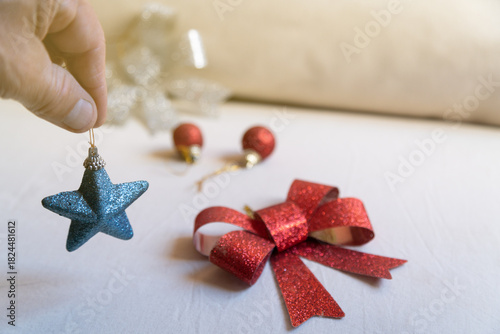 Hand holding blue glitter star christmas ornament