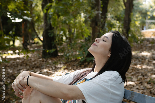 Young woman enjoying tranquility in nature, soaking up sunlight and finding peace outdoors