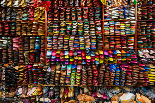 Colorful display of traditional footwear neatly arranged on shelves in a market stall. Fez, Fez-Meknes, Northern Inland Morocco