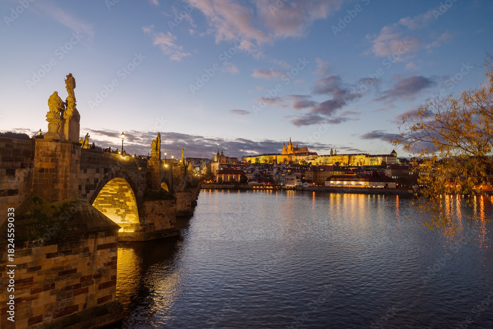 Obraz premium Castle of Prague and Charles bridge reflected on Vltava river at sunset