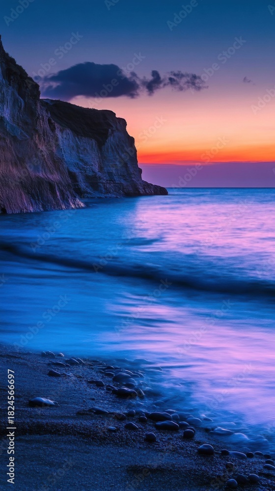 Fototapeta premium Coastal cliff with bioluminescent waves at sunset