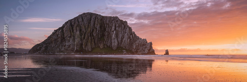 Photos Coastal Monolith Reflected on a Calm Shore at Sunset