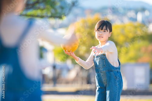公園でドッジボールをして遊ぶ元気な女の子