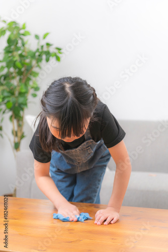 自宅でテーブルを拭く女の子のお手伝いシーン