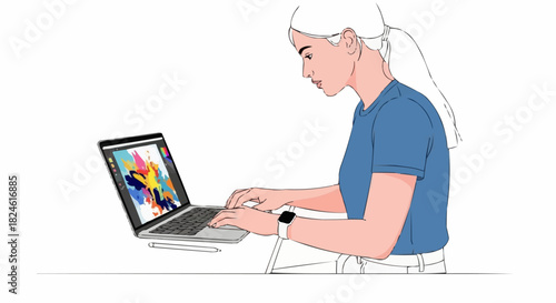 Young woman focused on her laptop screen working on a creative project.