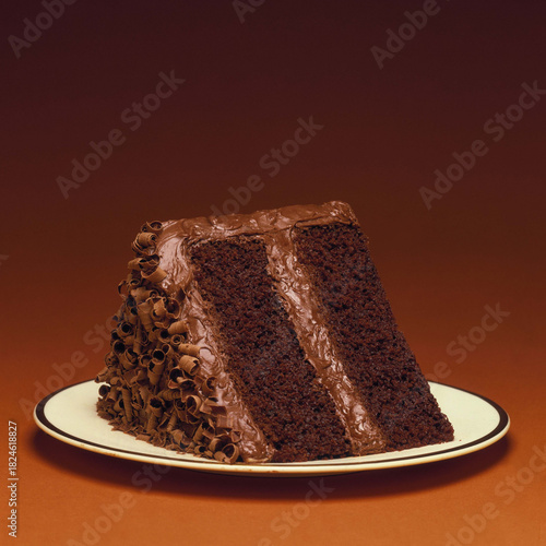 Indulge your senses with this decadent chocolate cake slice, a sweet temptation featuring rich frosting and delightful chocolate curls, perfect for cravings