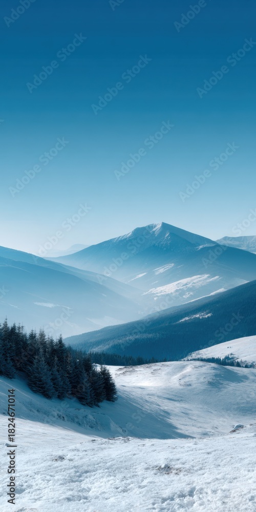 Fototapeta premium Serene winter mountain landscape with snow-covered peaks and pine forest