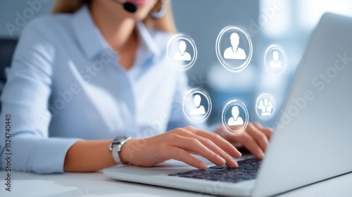 In a contemporary office space, a woman is focused on her laptop while wearing a headset.