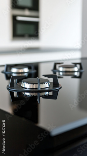 Sleek modern kitchen with shiny black gas burners on a stovetop.