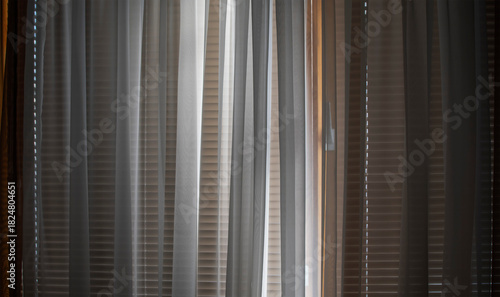 The window in the room is covered with blinds and curtains