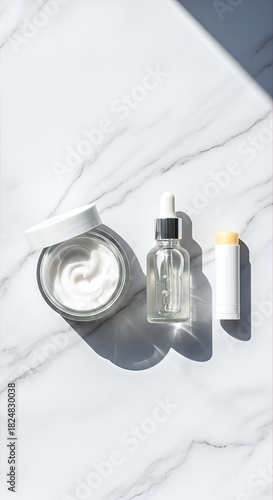 Skincare products on marble background with natural light and shadows, beauty routine essentials.