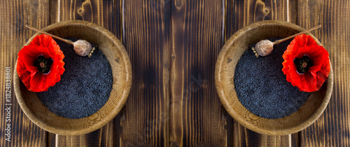 Poppy seeds and poppy flower in the brown bowls on a wooden background. Top view. Copy space.