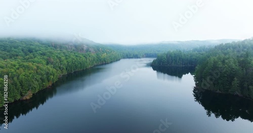 Backward motion  of an idyllic high angle scene of a misty lake and forest