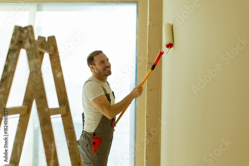 Man painting a wall with a ...
