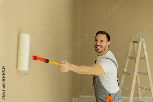 Man painting a wall with a ...