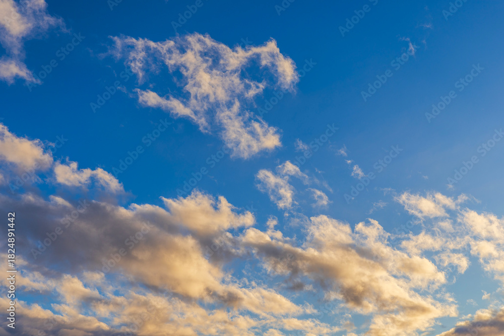 Fototapeta premium Beautiful view of golden clouds drifting across blue sky. Sweden.