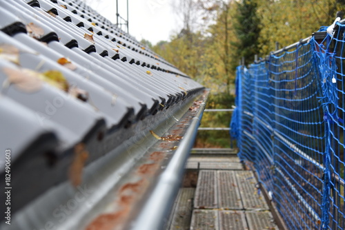 Ein dunkelgraues Dach mit einer Regenrinne bei einem neuen Haus