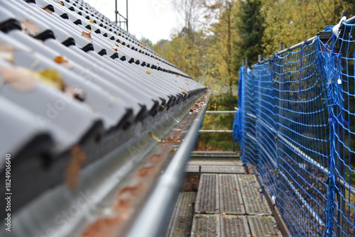 Ein dunkelgraues Dach mit einer Regenrinne bei einem neuen Haus
