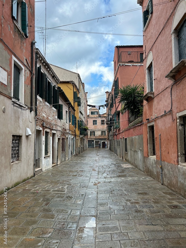 Fototapeta premium Empty Venetian Campo with Colorful Historic Buildings and Wet Pavement. Narrow street in venice