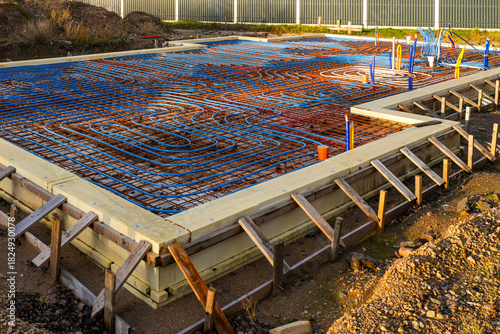 Underfloor heating system with pipes installed over rebar grid before concrete slab pouring