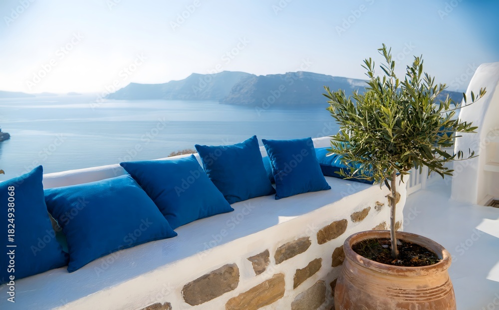 Fototapeta premium Blue pillows on white terrace wall overlooking sea, traditional Santorini island architecture with olive tree pot, luxury summer vacation resort view, greek mediterranean landscape.