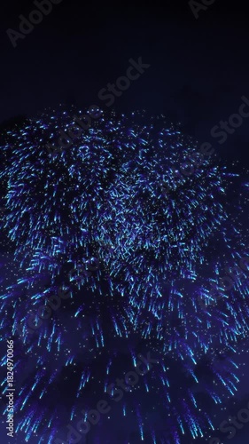 Dynamic greeting card background, Merry Christmas and Happy New Year 2026, vibrant blue fireworks exploding, dazzling pyrotechnic bursts lighting up dark night sky, festive celebration, Copy space