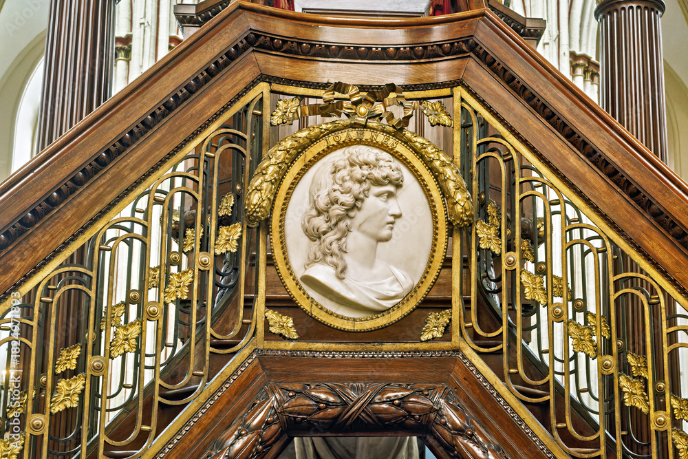 Obraz premium detail of an ornate structure, likely a pulpit loft staircase, featuring a marble or stone relief medallion of a classical profile inside St Salvador Cathedral, Bruges, Belgium 