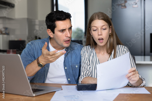 Принти на полотні Shocked couple reviewing unexpected bills at home